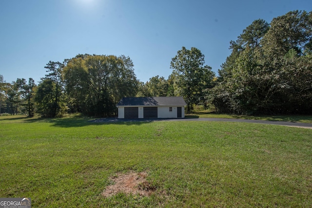 view of front of home featuring a front yard and an outbuilding