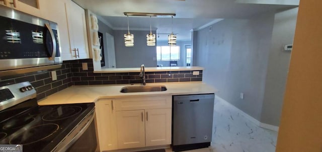 kitchen featuring sink, hanging light fixtures, stainless steel appliances, decorative backsplash, and white cabinets