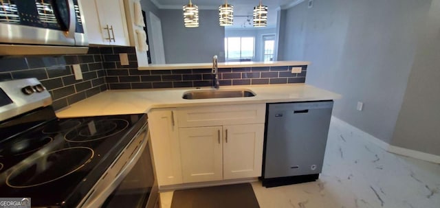 kitchen with white cabinets, appliances with stainless steel finishes, pendant lighting, and sink