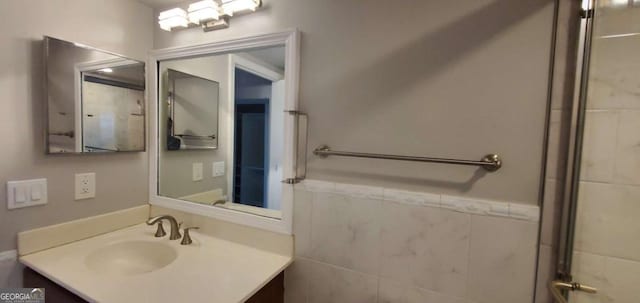 bathroom with vanity and tile walls