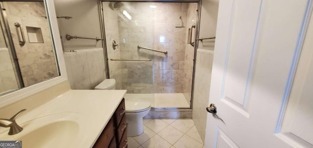 bathroom featuring toilet, vanity, tile patterned floors, and an enclosed shower