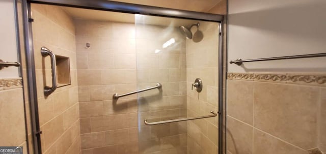 bathroom with tile walls and an enclosed shower