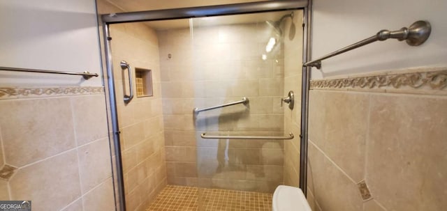 bathroom with toilet and a shower with door