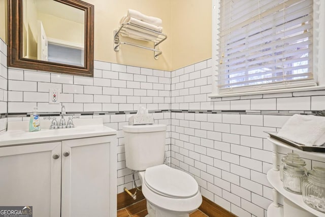 bathroom with vanity, tile walls, and toilet