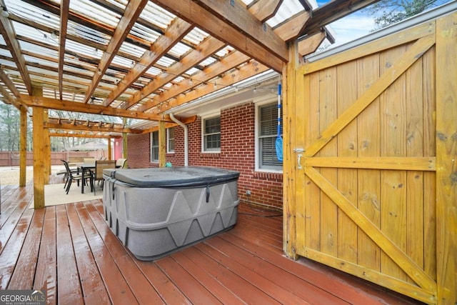 wooden deck with a pergola and a hot tub