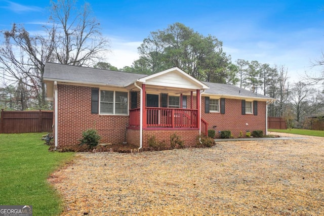 ranch-style home with covered porch and a front yard