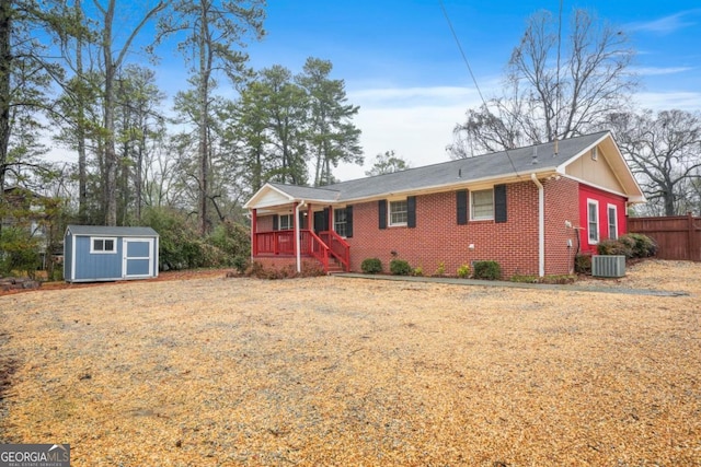 ranch-style house with central AC, covered porch, and a storage shed