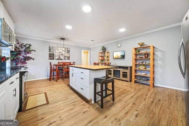 kitchen with white cabinets, pendant lighting, and light hardwood / wood-style floors