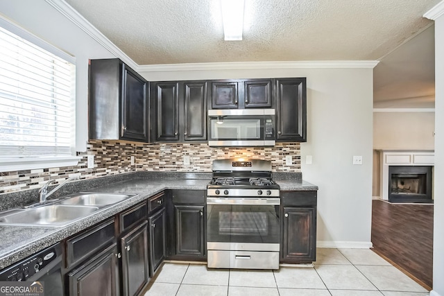 kitchen featuring sink, light tile patterned floors, a textured ceiling, and appliances with stainless steel finishes