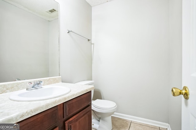 bathroom with tile patterned floors, vanity, a textured ceiling, and toilet