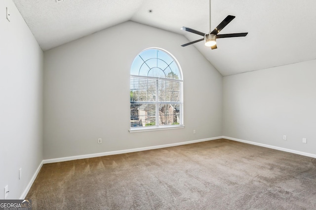 empty room featuring carpet, vaulted ceiling, and ceiling fan