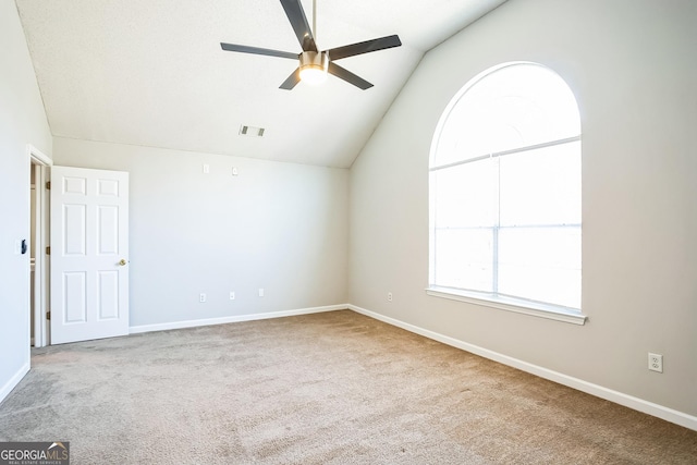 empty room with ceiling fan, lofted ceiling, and carpet floors