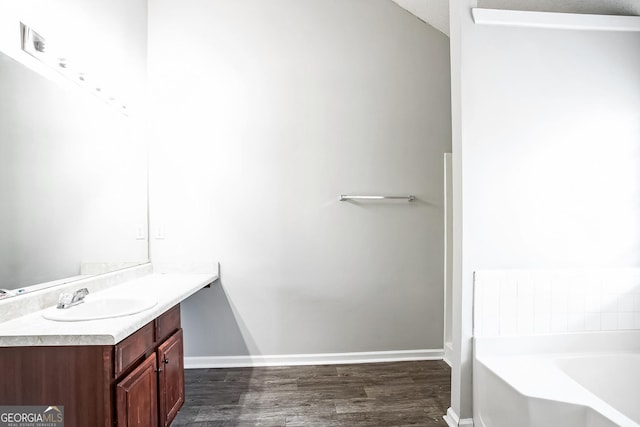 bathroom featuring hardwood / wood-style floors, a bathtub, and vanity