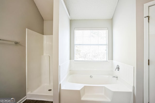 bathroom with plus walk in shower and a textured ceiling