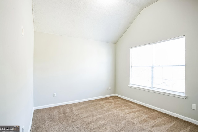 unfurnished room with carpet and vaulted ceiling