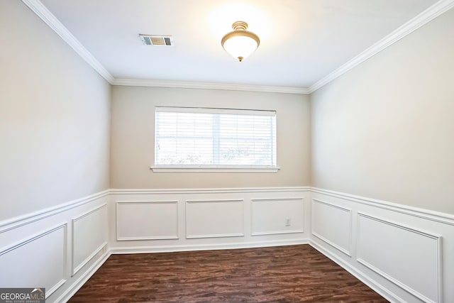 spare room featuring ornamental molding and dark wood-type flooring