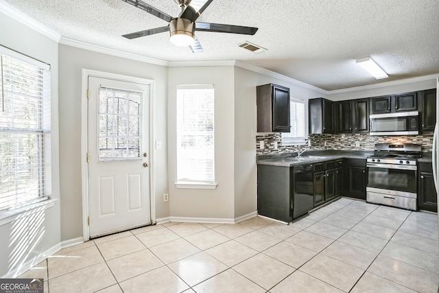 kitchen featuring backsplash, sink, ceiling fan, light tile patterned floors, and appliances with stainless steel finishes