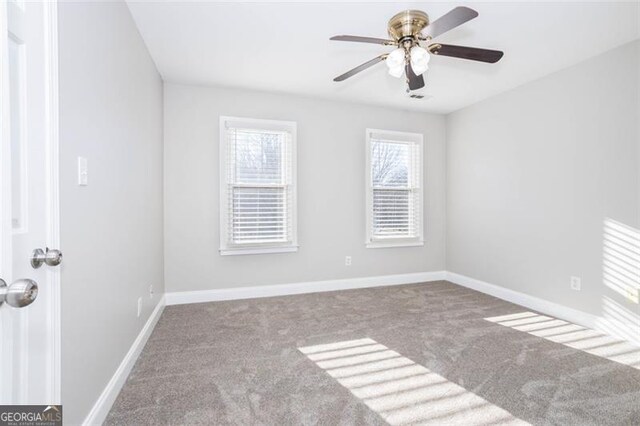 spare room featuring ceiling fan and carpet floors