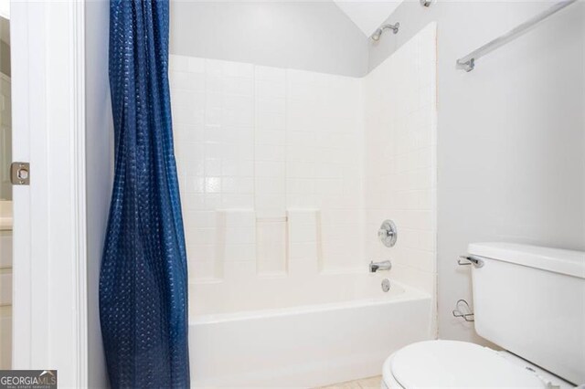 bathroom featuring tile patterned flooring, toilet, and shower / bath combo with shower curtain