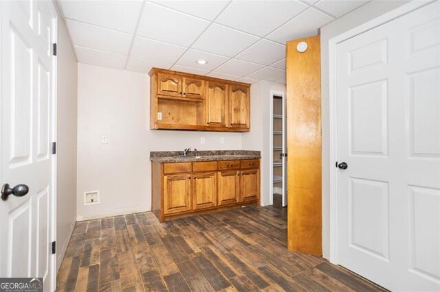 kitchen with a paneled ceiling, sink, and dark hardwood / wood-style floors