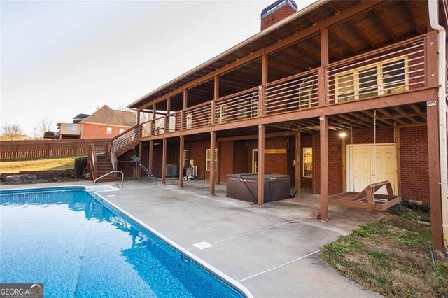 view of swimming pool with a deck, a patio, and a hot tub