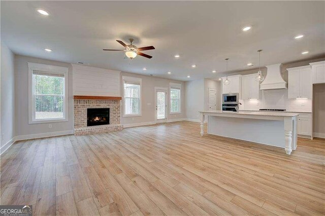 unfurnished living room featuring light hardwood / wood-style floors and ceiling fan