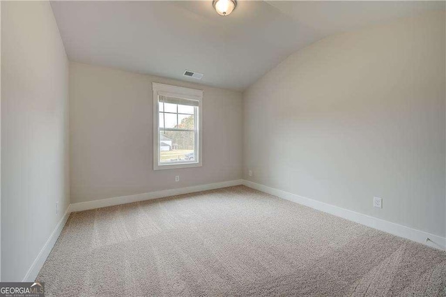 carpeted spare room featuring lofted ceiling