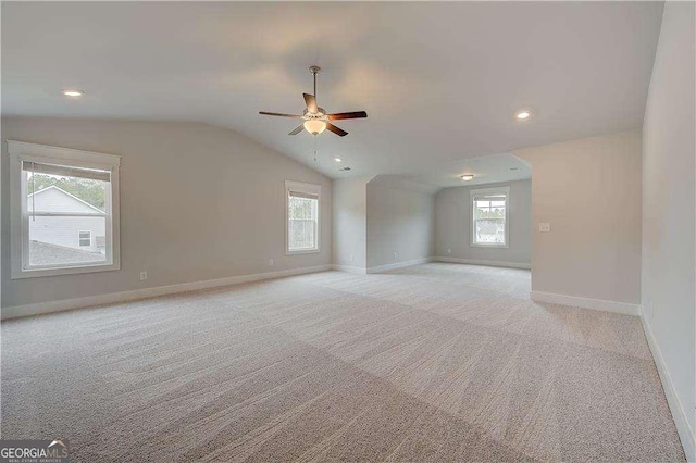 carpeted empty room with vaulted ceiling and ceiling fan