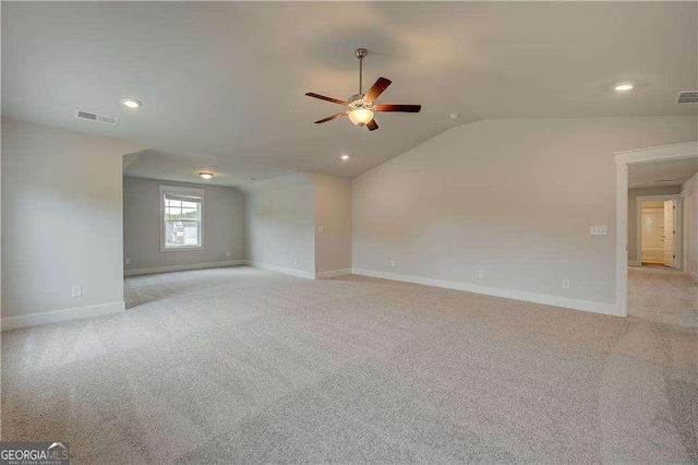 spare room featuring ceiling fan, light colored carpet, and lofted ceiling