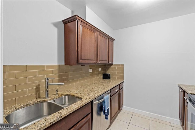 kitchen with light stone countertops, dishwasher, sink, backsplash, and light tile patterned flooring