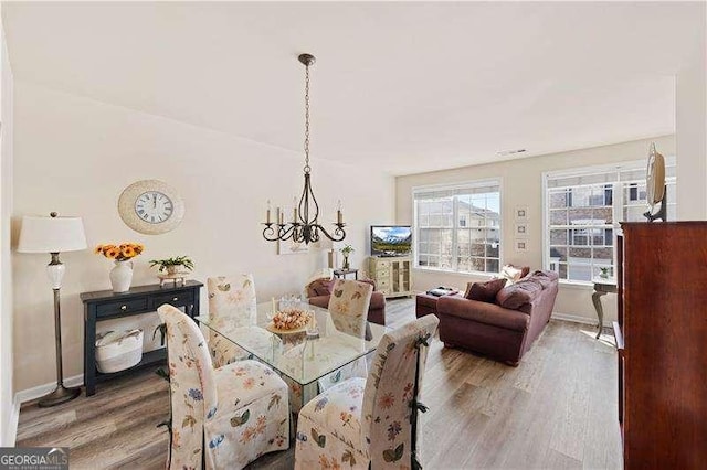 dining room featuring hardwood / wood-style floors and an inviting chandelier