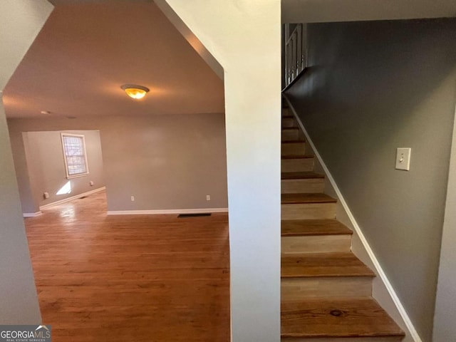 staircase with hardwood / wood-style flooring