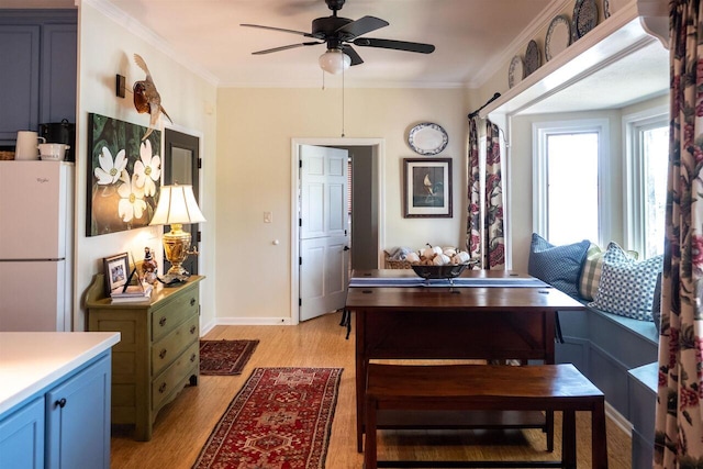 dining area with light wood-type flooring, ceiling fan, and ornamental molding