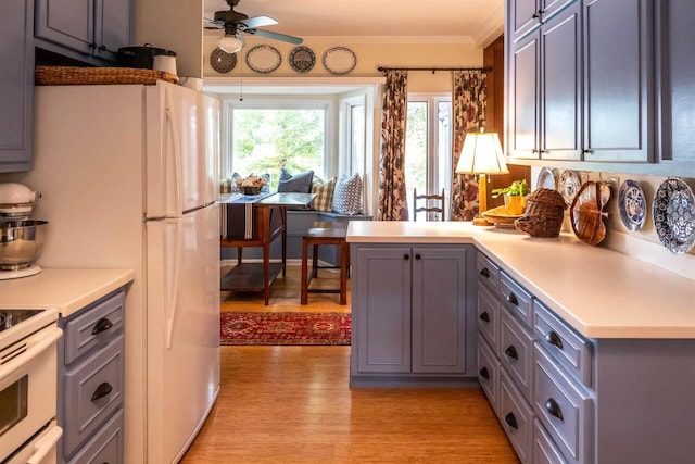 kitchen featuring kitchen peninsula, white range, ceiling fan, crown molding, and light hardwood / wood-style flooring