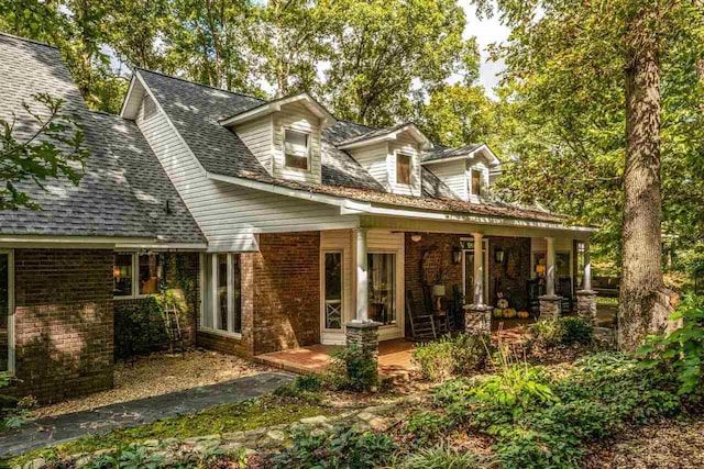 rear view of property featuring a porch