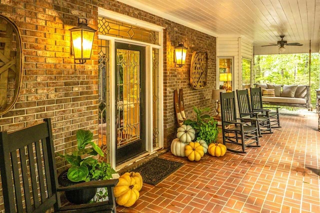 view of exterior entry featuring ceiling fan and covered porch