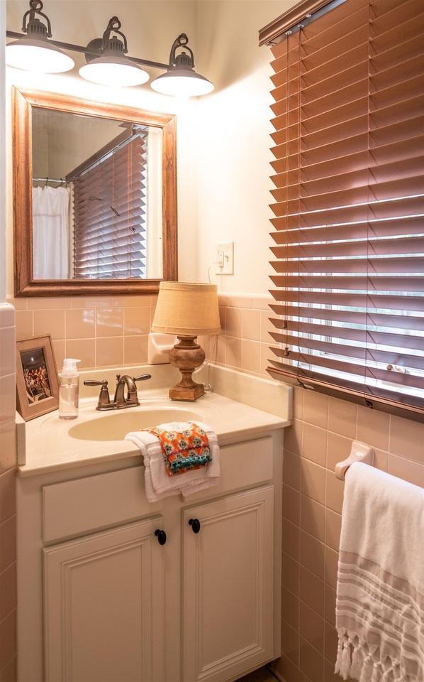 bathroom featuring vanity and tile walls