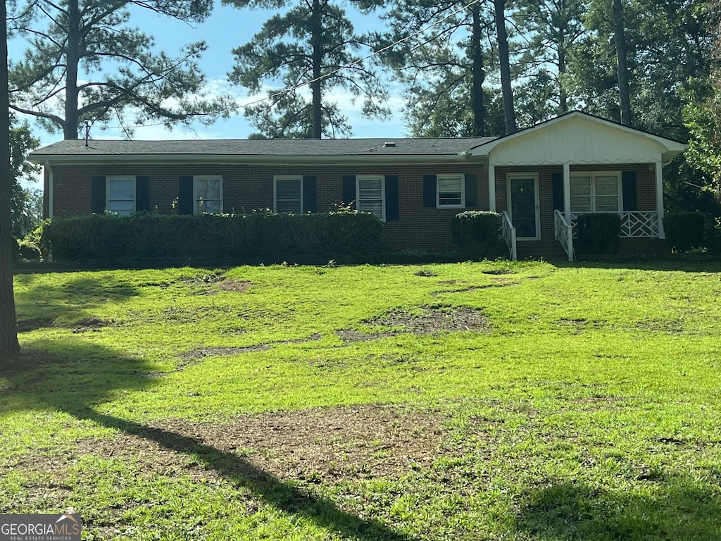 ranch-style house featuring a front lawn and a porch