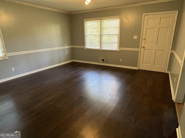 spare room featuring crown molding and dark wood-type flooring