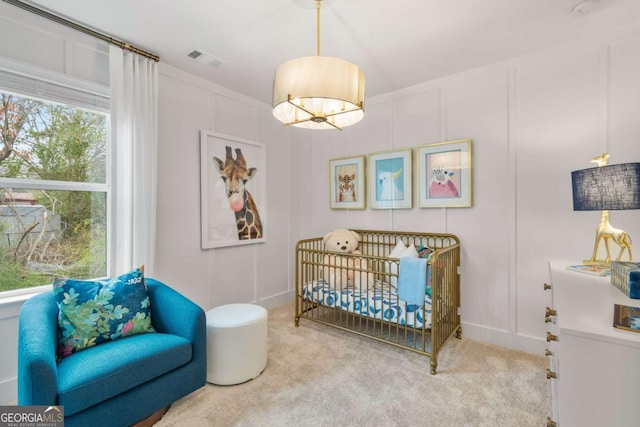 carpeted bedroom with a nursery area