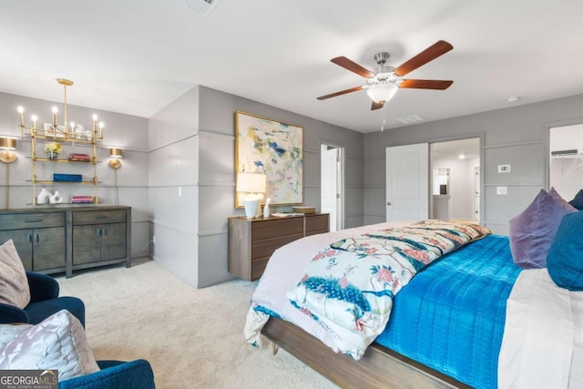 bedroom featuring light carpet and ceiling fan with notable chandelier