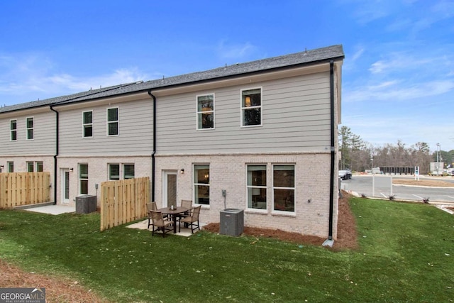 rear view of property featuring cooling unit and a yard