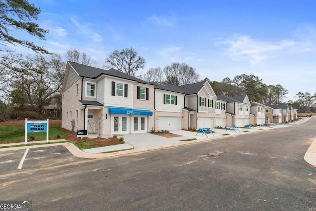 townhome / multi-family property featuring a garage and french doors