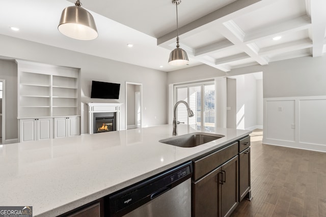 kitchen with light stone counters, sink, decorative light fixtures, beamed ceiling, and dishwasher