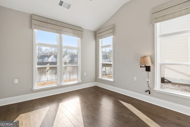 spare room with dark hardwood / wood-style floors and vaulted ceiling