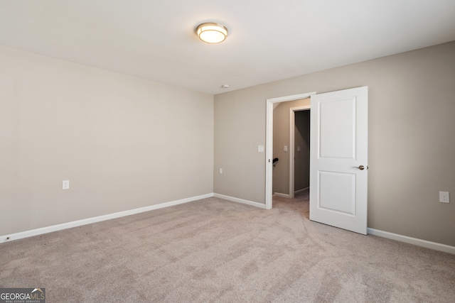 unfurnished room featuring light carpet