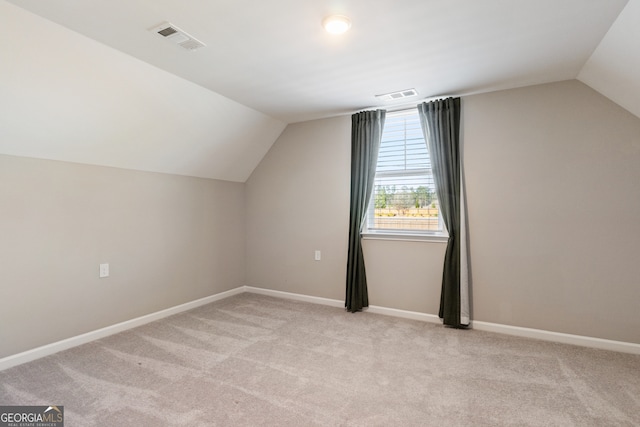 bonus room featuring light carpet and vaulted ceiling