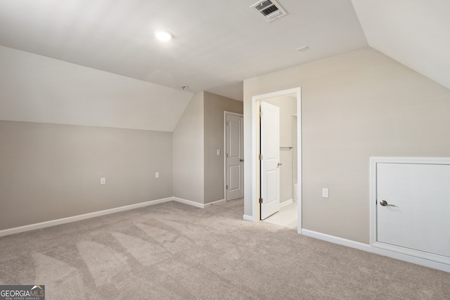 additional living space with light carpet and vaulted ceiling