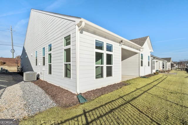 view of property exterior featuring central AC and a yard