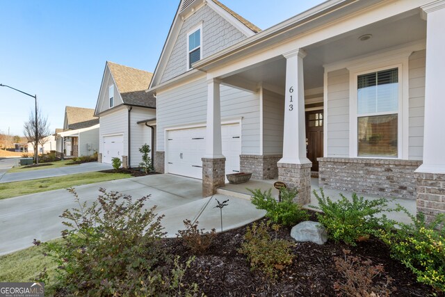 view of property exterior with a garage and covered porch